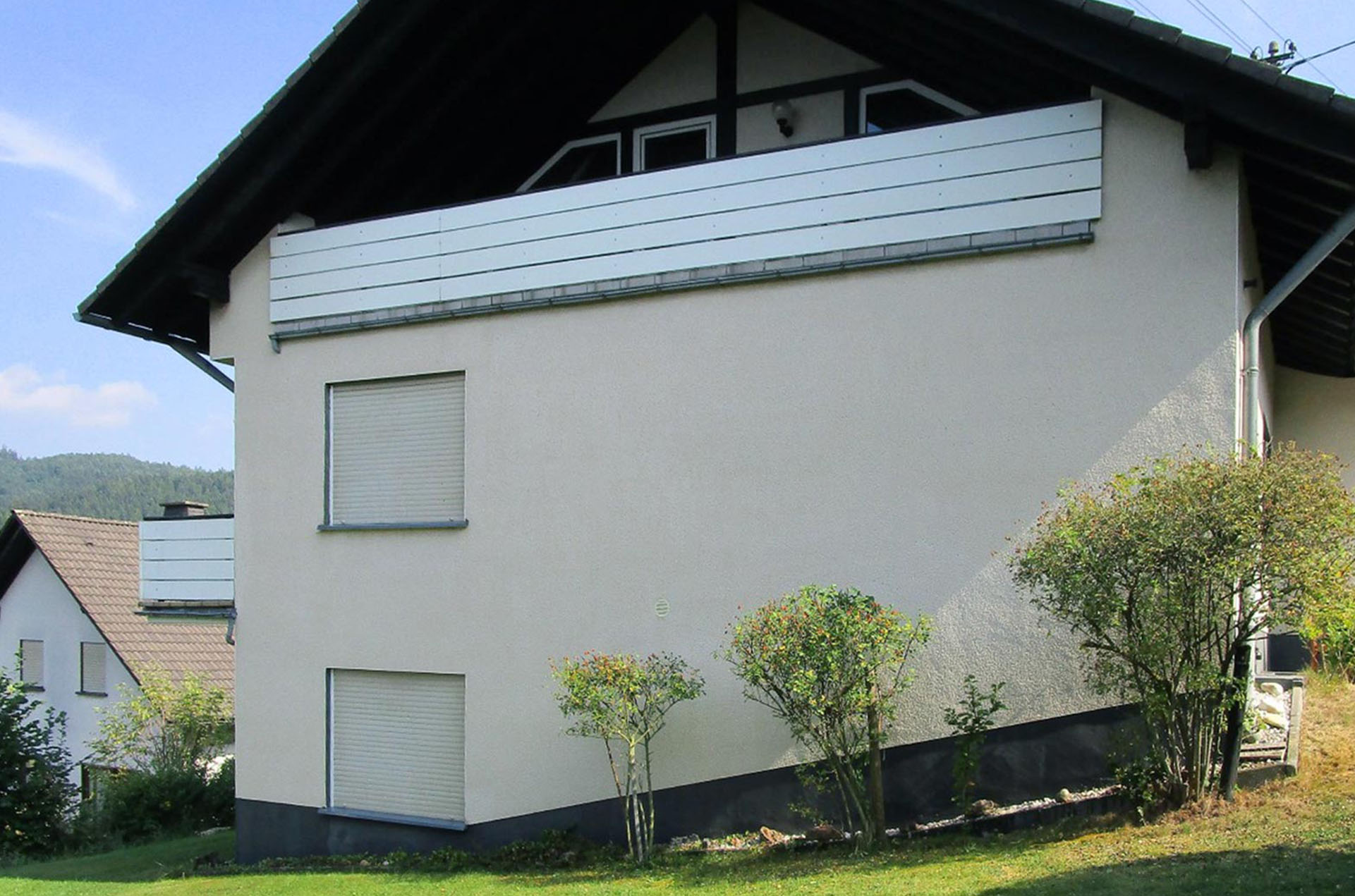 Saubere Außenfassade eines Gebäudes mit Balkon nach der Fassadenreinigung.